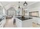 Stylish kitchen with island, black countertops, white cabinets, open to a comfortable living area with vaulted ceiling at 7640 Harbour Walk, Cumming, GA 30041