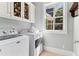 Convenient laundry room with modern washer and dryer units and storage cabinets at 7640 Harbour Walk, Cumming, GA 30041