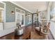 Comfortable covered porch including seating options and views of the surrounding wooded landscape at 7640 Harbour Walk, Cumming, GA 30041