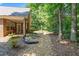 The back of the house leading to a pebble-covered yard and a forested area at 1152 Strath Clyde Way, Mcdonough, GA 30253