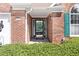Close-up of the home's entryway showcasing a decorative glass door, brick facade, and bright green shutters at 1152 Strath Clyde Way, Mcdonough, GA 30253