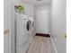 Laundry room featuring modern appliances, clean white walls, and a door to the main house at 1152 Strath Clyde Way, Mcdonough, GA 30253