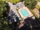 Aerial view of a community pool with lounge chairs, parking, tennis court and a neighboring building at 1152 Strath Clyde Way, Mcdonough, GA 30253
