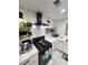 Stylish kitchen featuring white cabinets, a black gas range, and open shelves for storage at 1644 Alexandria Ct, Marietta, GA 30067