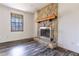 Close-up of the living room's stone fireplace and wood-look floors, enhanced by natural light at 1767 Wingard Dr, Marietta, GA 30062