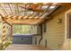 Back patio with a wooden trellis, ceiling fan, and lush trees and greenery at 1767 Wingard Dr, Marietta, GA 30062