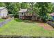 Large backyard featuring a deck, mature trees, and green grass, ideal for outdoor activities and entertaining at 3260 Sims View Ct, Snellville, GA 30078