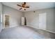 Spacious carpeted bedroom with a ceiling fan and doors to ensuite bathroom and closet at 3260 Sims View Ct, Snellville, GA 30078