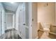 Hallway with wood-look flooring leading to a half bathroom with white cabinets and toilet at 3260 Sims View Ct, Snellville, GA 30078