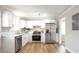 Modern kitchen with white cabinets, stainless steel appliances, granite countertops, and wood-look floors at 34 Kelso At Peyton Dr, Atlanta, GA 30311