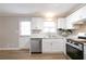 Bright and modern kitchen with white cabinets, stainless steel appliances and luxury vinyl plank flooring at 34 Kelso At Peyton Dr, Atlanta, GA 30311