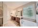 Well lit bathroom featuring double vanity, a shower, and a separate tub beneath a large window at 3270 New University Trl, Cumming, GA 30041