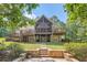 Exterior view with a sprawling deck, multiple stories, and meticulously landscaped grounds at 3270 New University Trl, Cumming, GA 30041