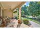 Inviting front porch with stone flooring, classic columns, and seating area, perfect for relaxing at 3270 New University Trl, Cumming, GA 30041