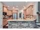 Stylish kitchen featuring stone counter, breakfast bar, stainless steel appliances, and hanging lights at 3270 New University Trl, Cumming, GA 30041