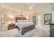 Spacious main bedroom featuring a tray ceiling, ceiling fan, neutral carpet and light fixtures at 3270 New University Trl, Cumming, GA 30041