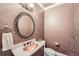 Elegant powder room with bronze colored sink, decorative mirror, and wallpaper at 3270 New University Trl, Cumming, GA 30041