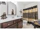 A bathroom featuring a dark vanity, unique decor, and a shower curtain at 3316 Quarter Horse Ln, Conyers, GA 30013