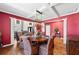 Formal dining room features hardwood floors, red accent wall and a modern chandelier above the table at 3316 Quarter Horse Ln, Conyers, GA 30013