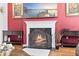 Living room fireplace with black trim, wood floors, and red accent wall at 3316 Quarter Horse Ln, Conyers, GA 30013