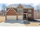 Two-story brick and stone home with manicured front lawn, a two-car garage, and a covered front entrance at 3316 Quarter Horse Ln, Conyers, GA 30013