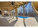 Covered patio area with ceiling fans, with views of the inground pool, surrounded by fence and trees at 3316 Quarter Horse Ln, Conyers, GA 30013