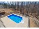 Elevated view of the backyard swimming pool surrounded by a concrete patio and black metal fence with trees at 3316 Quarter Horse Ln, Conyers, GA 30013