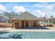 View of the brick pool house with multiple entrances, adjacent to covered in-ground pool at 3316 Quarter Horse Ln, Conyers, GA 30013