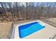 Aerial view of backyard swimming pool and surrounding black metal fence, concrete patio and trees in background at 3316 Quarter Horse Ln, Conyers, GA 30013