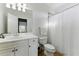 Clean bathroom featuring a white vanity, toilet, shower with curtain, and ample lighting at 4080 Glen Hill Ne Way, Marietta, GA 30066