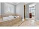 Luxurious bathroom with a tiled jacuzzi tub, tiled floors, and natural light at 4080 Glen Hill Ne Way, Marietta, GA 30066