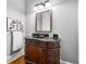 Charming powder room with ornate wood vanity, dark countertop, decorative mirror, and stylish fixtures at 4080 Glen Hill Ne Way, Marietta, GA 30066