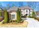 Elegant brick home featuring a well-manicured lawn, mature evergreens, and a spacious driveway on a sunny day at 4080 Glen Hill Ne Way, Marietta, GA 30066