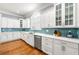 Well-lit kitchen with white cabinets, stainless steel appliances, and unique blue tile backsplash at 4080 Glen Hill Ne Way, Marietta, GA 30066