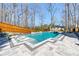 Backyard pool with built-in lounge chairs, a spa, modern pavers, and a surrounding wooden fence at 4080 Glen Hill Ne Way, Marietta, GA 30066