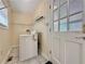 Bright laundry room features tile flooring, overhead rack, and a washing machine near a window and the back door at 248 Arnold Ave, Marietta, GA 30066