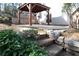 Backyard featuring stone steps, lush greenery, and a wooden pergola with furniture at 3572 Dexter Way, Marietta, GA 30062