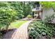 Lush backyard featuring a brick walkway, mature trees, and verdant landscaping at 3572 Dexter Way, Marietta, GA 30062