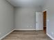 A minimalist bedroom with hardwood floors, a door, and neutral colored walls at 68 Hardy Water Dr, Lawrenceville, GA 30045