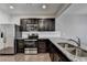 Bright kitchen with stainless steel appliances, granite countertops, tile backsplash, and dark cabinets at 68 Hardy Water Dr, Lawrenceville, GA 30045