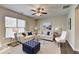 Cozy living room with comfortable seating, a ceiling fan, large windows, and a decorative area rug at 68 Hardy Water Dr, Lawrenceville, GA 30045