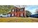 Charming brick two-story home with manicured lawn and a red front door at 3897 Vine Stone Dr, Stonecrest, GA 30038