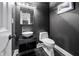 This powder room features a modern sink, toilet, and black-painted walls at 2870 Pharr Ct # 3002, Atlanta, GA 30305