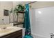 Bathroom featuring vanity, mirror, plants, shower with patterned curtain, and white-tiled tub at 6545 Muirfield Pt, Fairburn, GA 30213