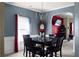 Dining room with traditional chandelier and dark-wood table setting, connecting seamlessly to the living areas at 6545 Muirfield Pt, Fairburn, GA 30213
