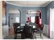 Open-concept dining room featuring a dark wood table, four chairs, and views into the living room at 6545 Muirfield Pt, Fairburn, GA 30213