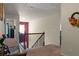 Second floor hallway with stairs, and a view into another room with natural light at 6545 Muirfield Pt, Fairburn, GA 30213