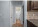 Hallway leads to a bathroom with a white shower and tile flooring; view of countertops on right at 6545 Muirfield Pt, Fairburn, GA 30213