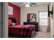 Bedroom featuring red accent wall, window with curtains, ceiling fan and neutral-colored carpet at 6545 Muirfield Pt, Fairburn, GA 30213