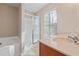 Bathroom featuring shower with glass door and single sink vanity under a window at 145 Sunset Ln, Woodstock, GA 30189